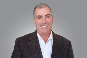 a headshot of David Glassman in a white shirt and black blazer